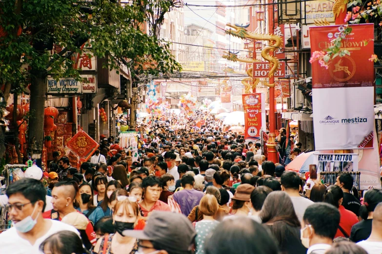 a large crowd of people walking down an oriental street