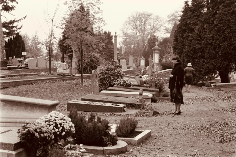 a black and white image of a man in a cemetery
