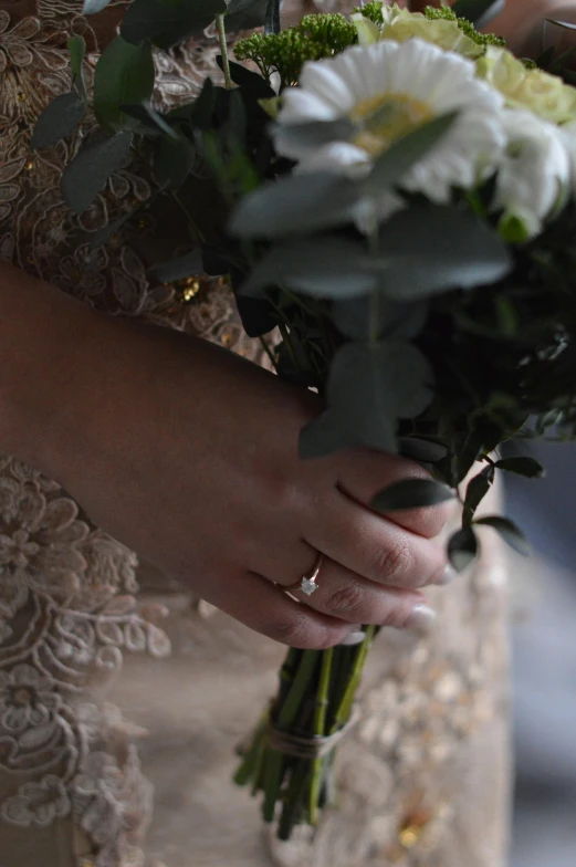 a woman holding onto an all white flower bouquet