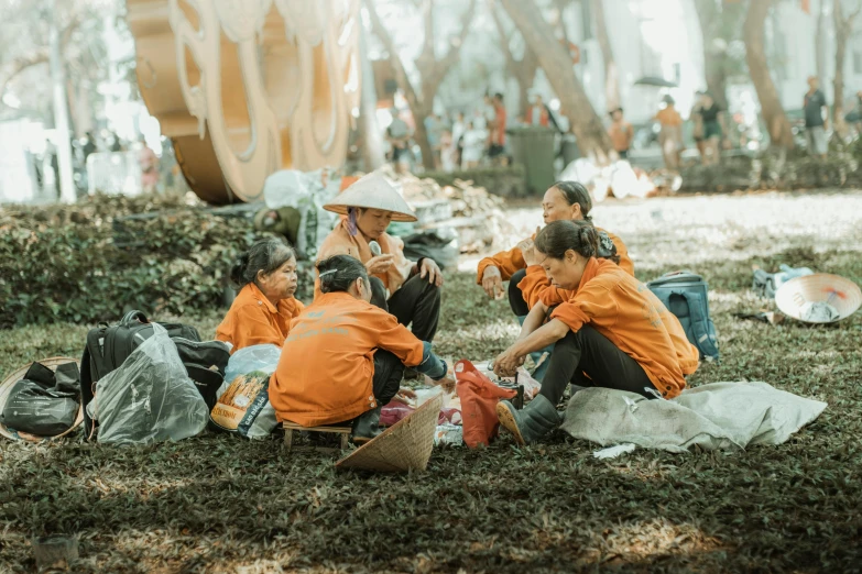 people sitting on the grass eating together