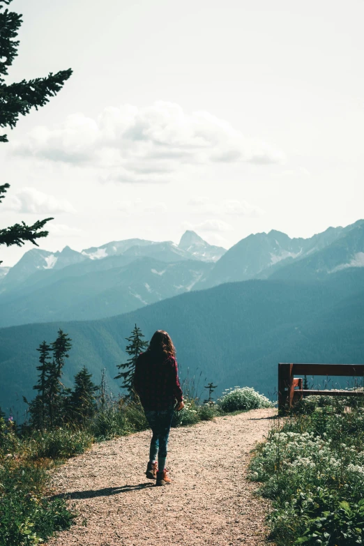 girl walking up a path toward a scenic view