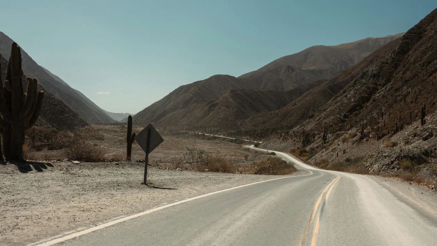 a desert road next to some mountains