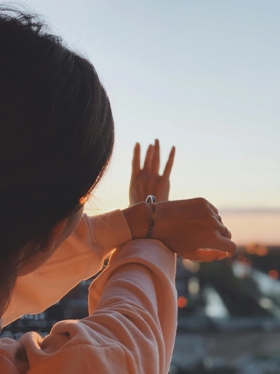 a girl making a vulcan signal over a cityscape