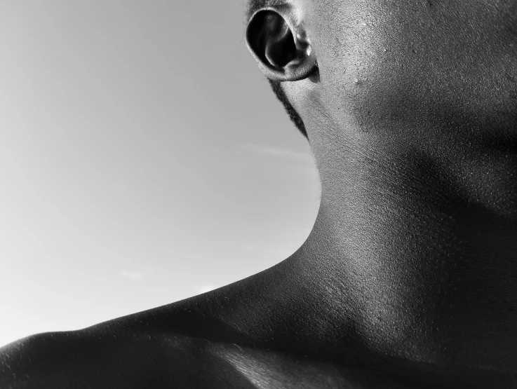 man with an ear piercing standing in a black and white po