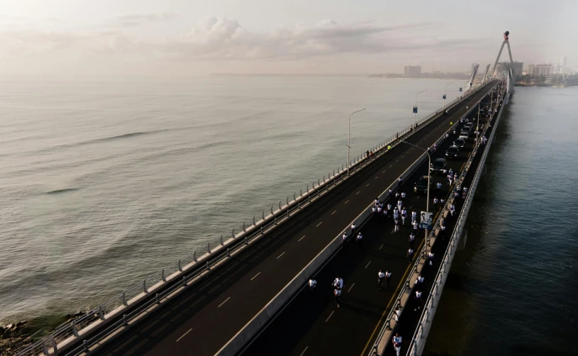 a long bridge across the ocean with cars on it