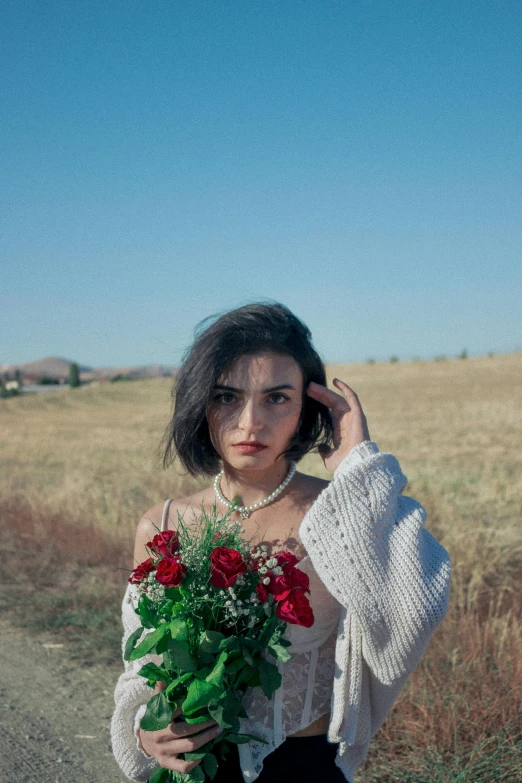 a woman holding flowers is looking at the camera