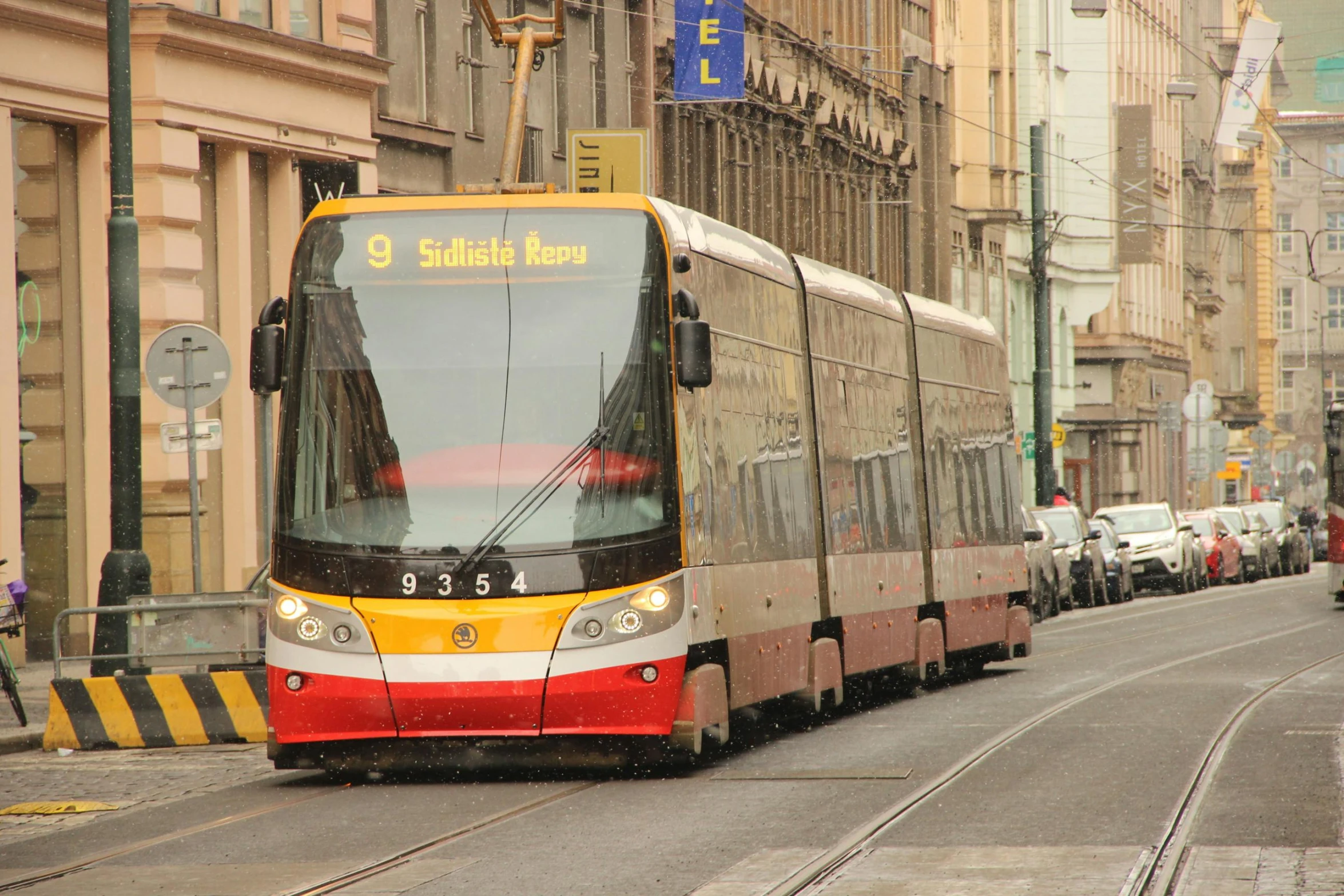 a yellow, black and white bus driving down the street