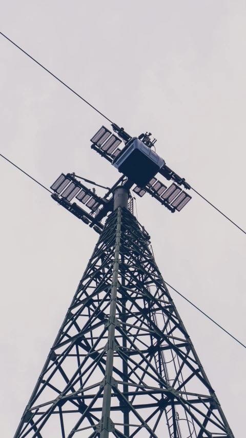 a radio tower under the grey sky is up