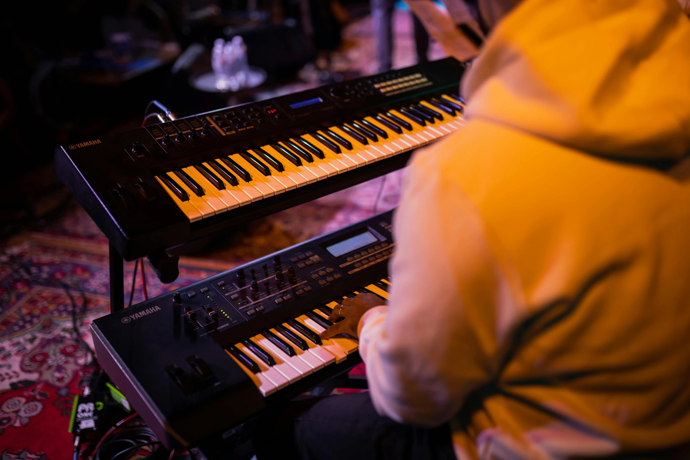 a person wearing a hooded jacket next to a keyboard