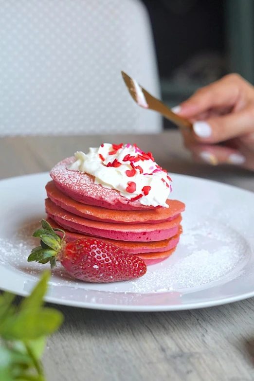 the person is picking up the strawberries on the plate