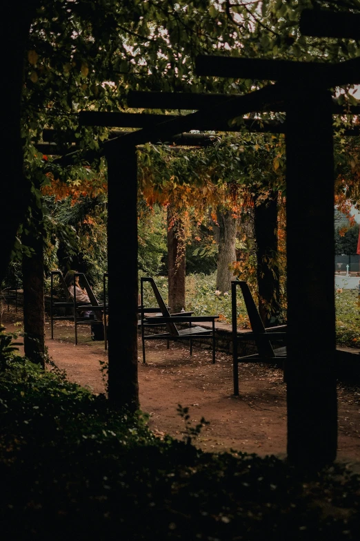 a park with several picnic tables and benches under the tree