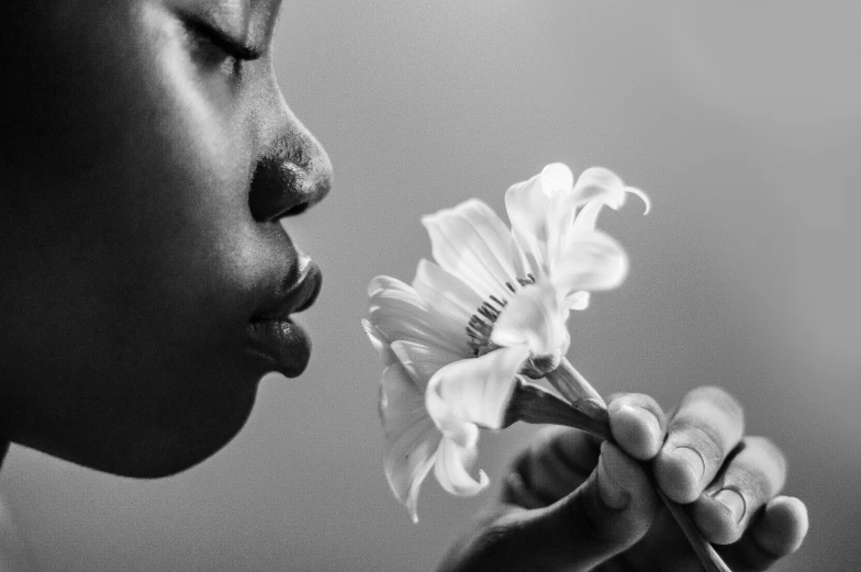 a woman has her nose close to a flower