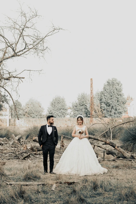 a bride and groom walking hand in hand in a clearing