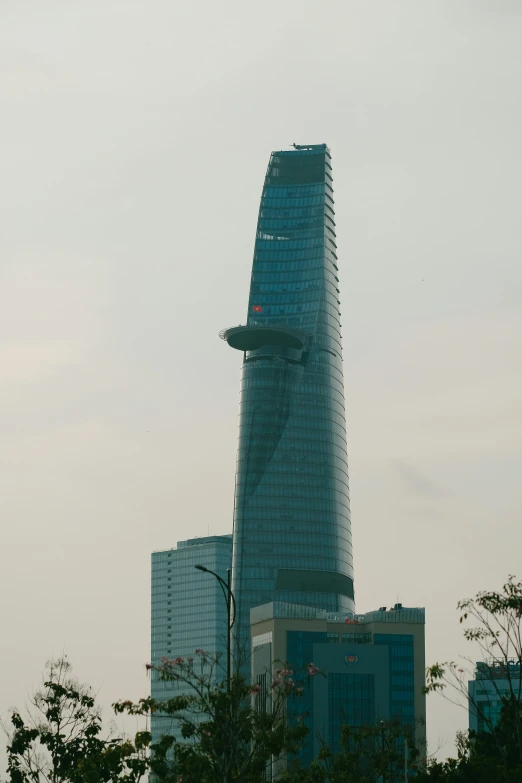 a large building sitting above trees and buildings