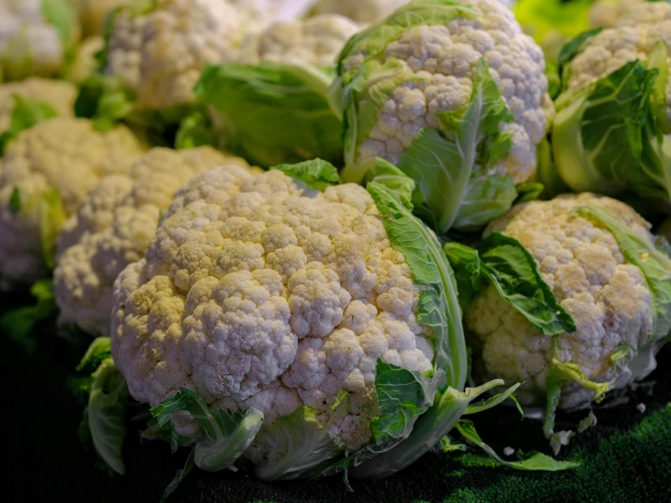 bunches of cauliflower are pictured stacked together