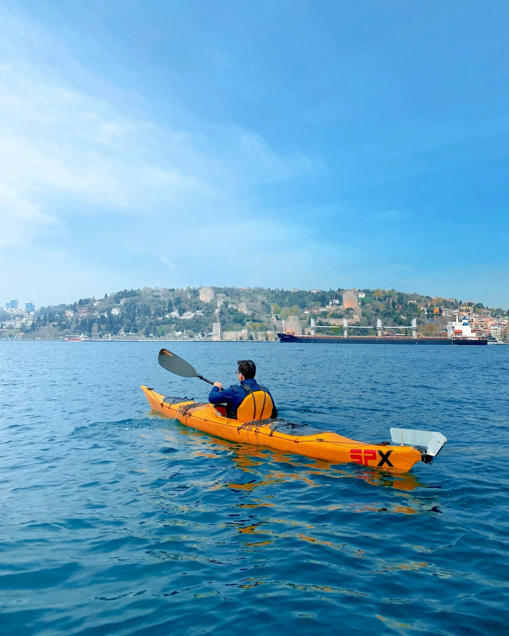 the man is rowing his yellow kayak on the lake