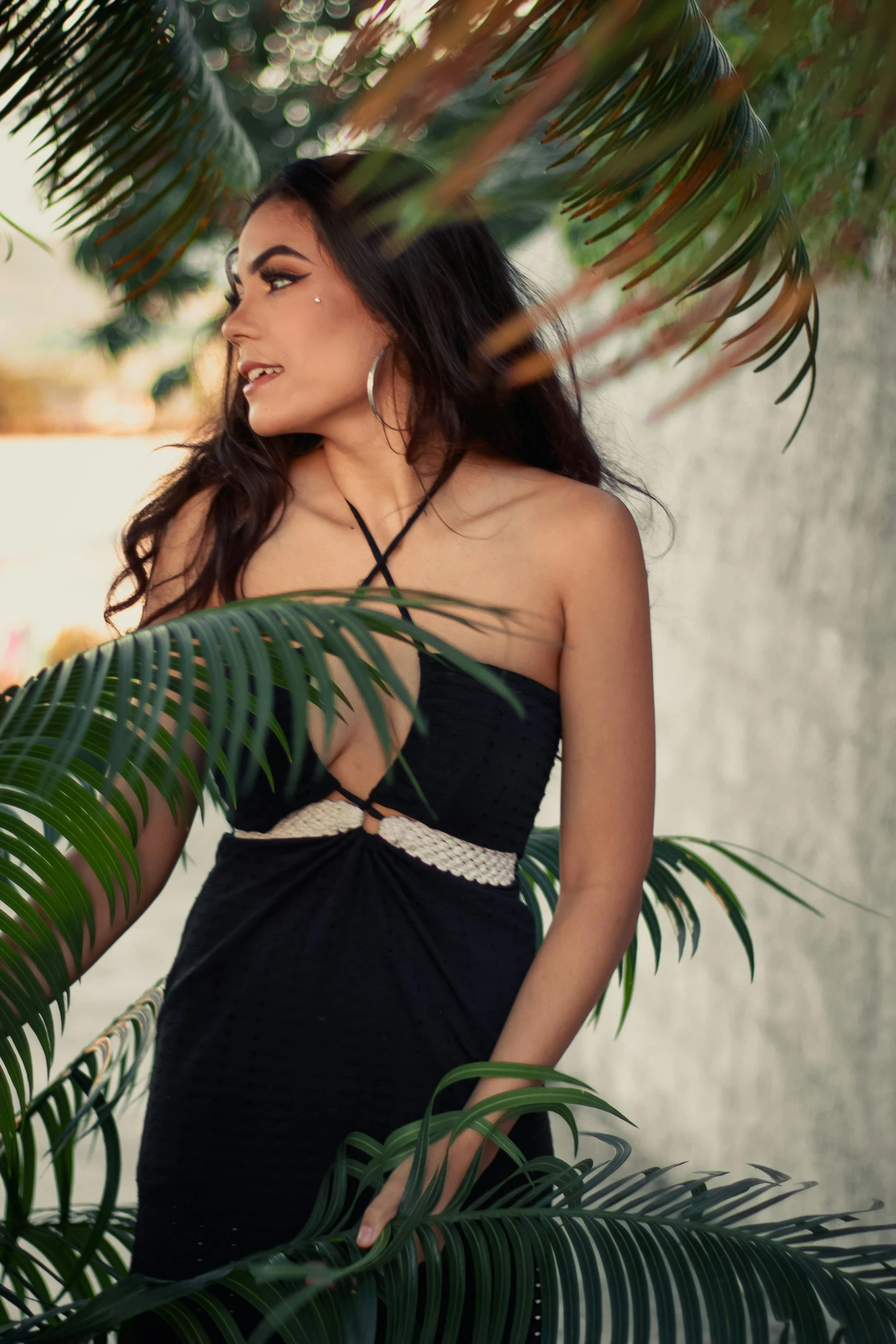 a woman posing in front of some leaves