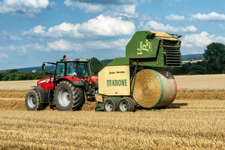 a farm truck pulling a bail of hay behind it