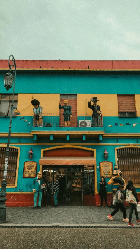 three people walk by an outdoor theater