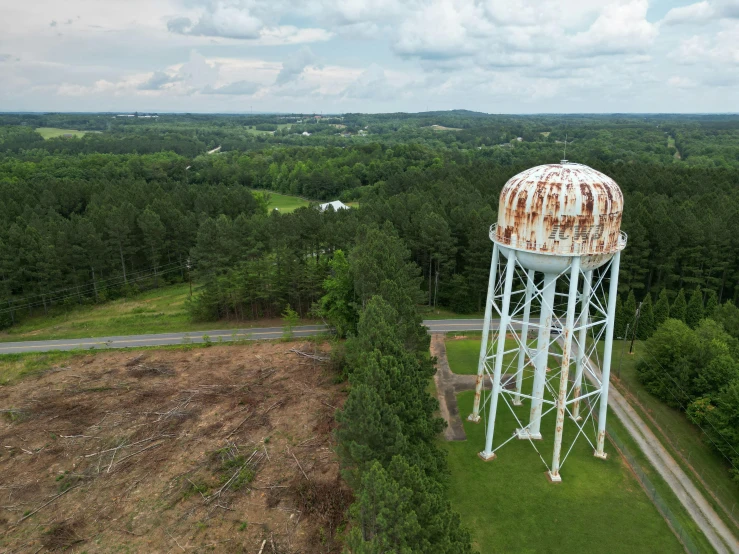 the large metal tank is on a dirt road in the middle of trees