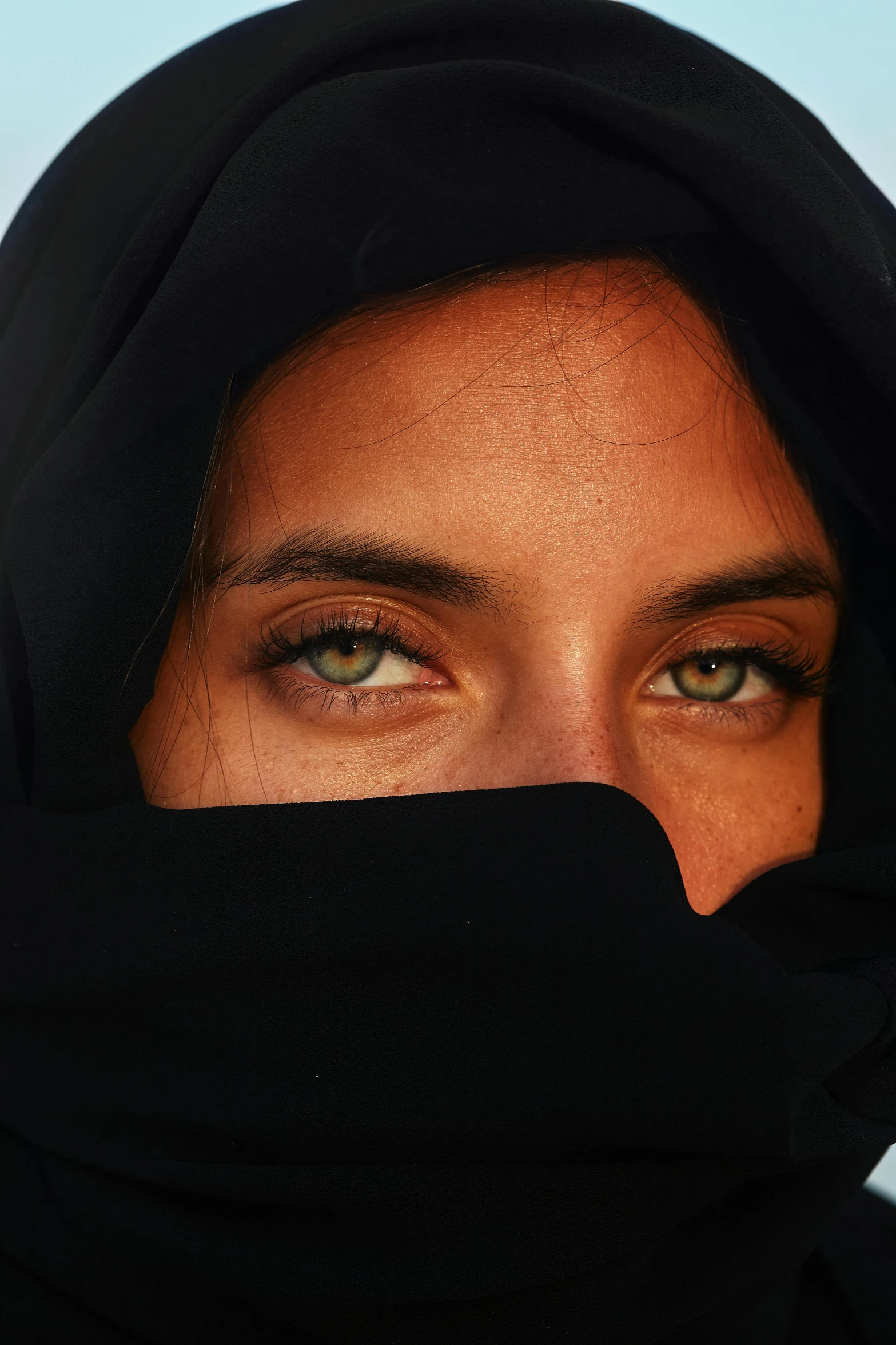 a close up po of an arabic woman wearing a black headscarf