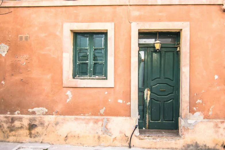 a building with a green door and a brown wall