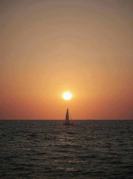 an ocean with a boat at sea during sunset