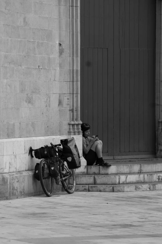 a man sitting on steps next to his bicycle