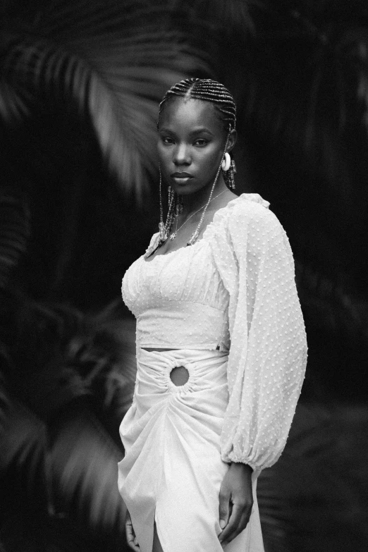 a beautiful woman in white dress posing with her hand on the hips