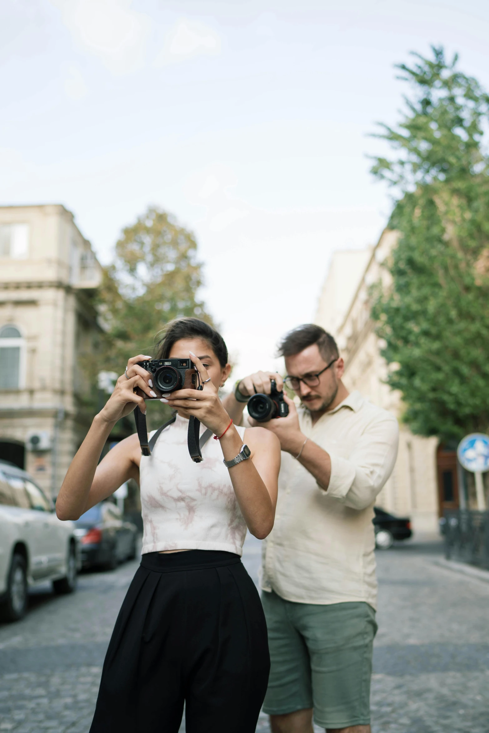 two people taking pictures in the middle of the street