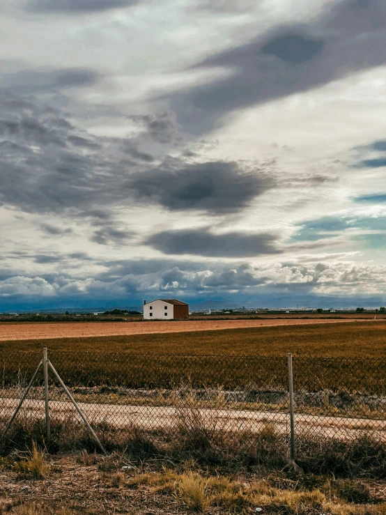 a fence surrounds a farm with a barn in the distance