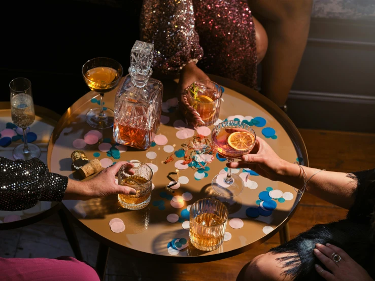 people holding wine glasses with different kinds of confections on a table