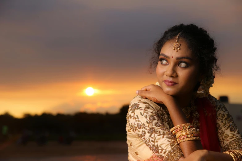 a woman posing for a po while the sun is setting