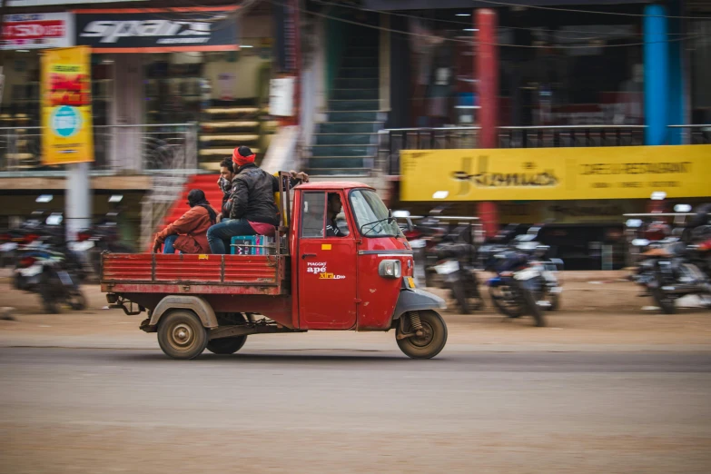 a red truck filled with people on the back of it