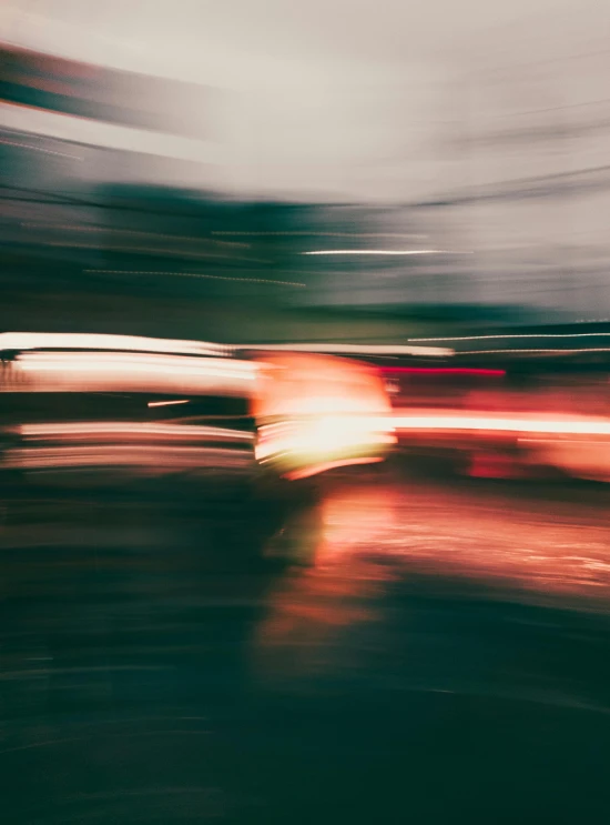 blurry image of a red car on road in the evening