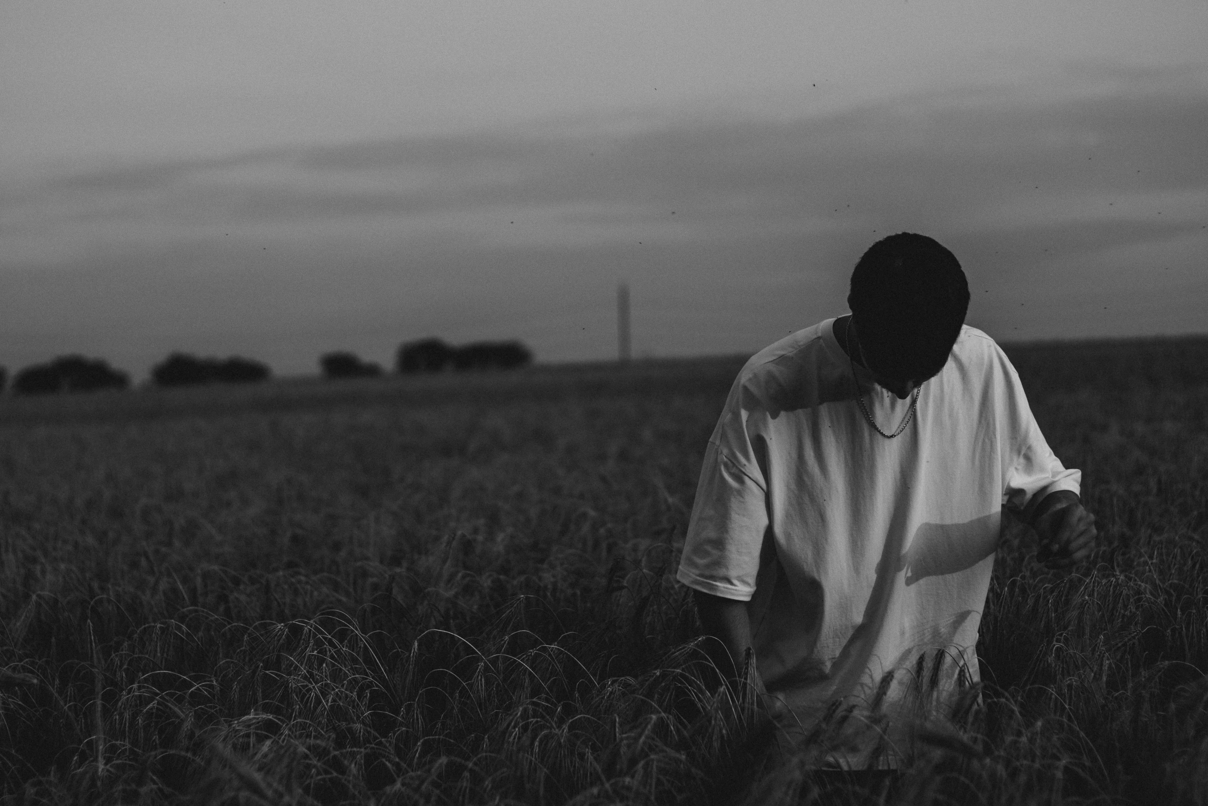 the boy is walking through the tall grass