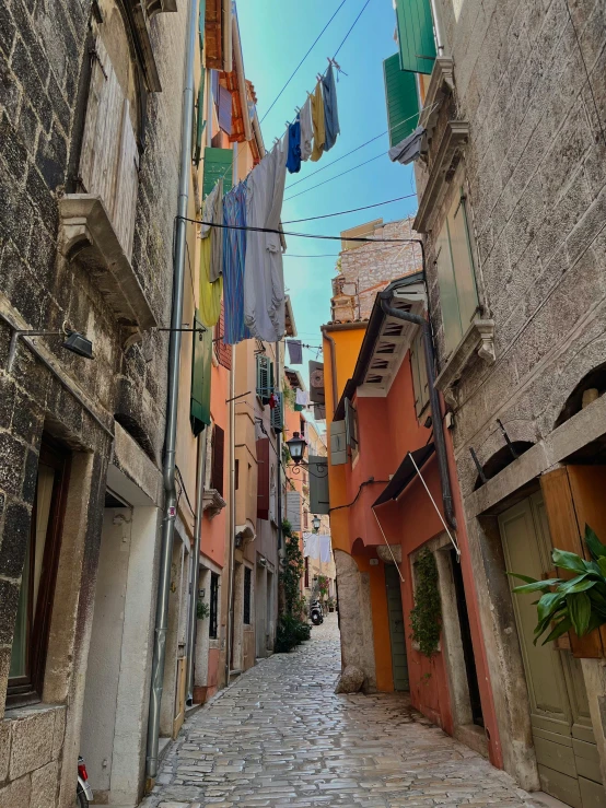 a street filled with old looking buildings and flags hanging