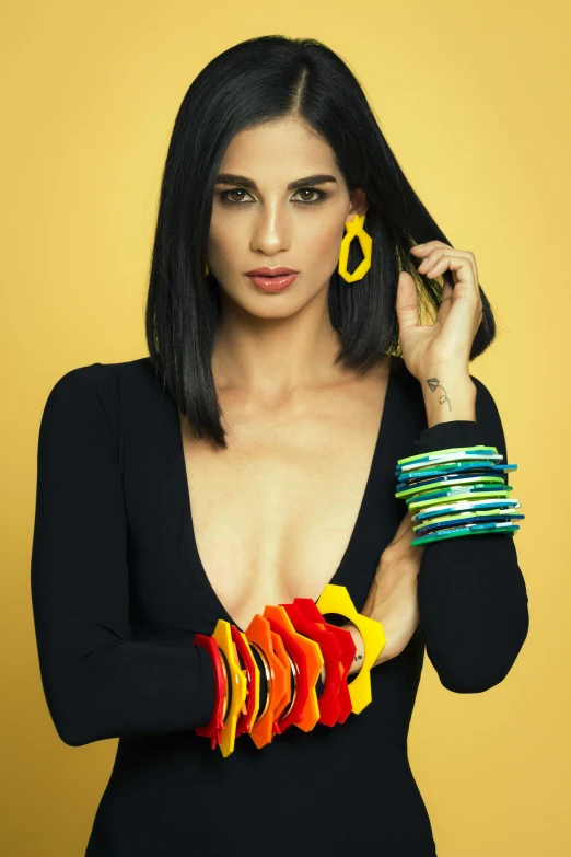 a woman in a dress with long arm bands and statement earrings