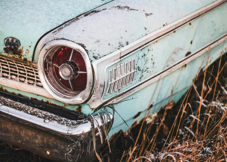 an old rusty old car sitting in a field