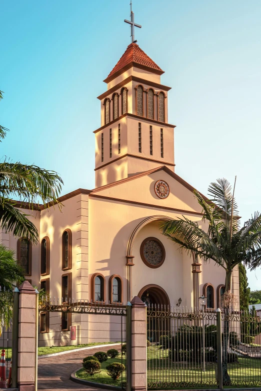 a church with a gated courtyard and cross on it