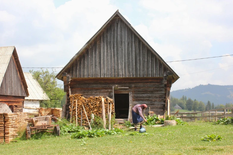 a man standing outside of a wooden shed