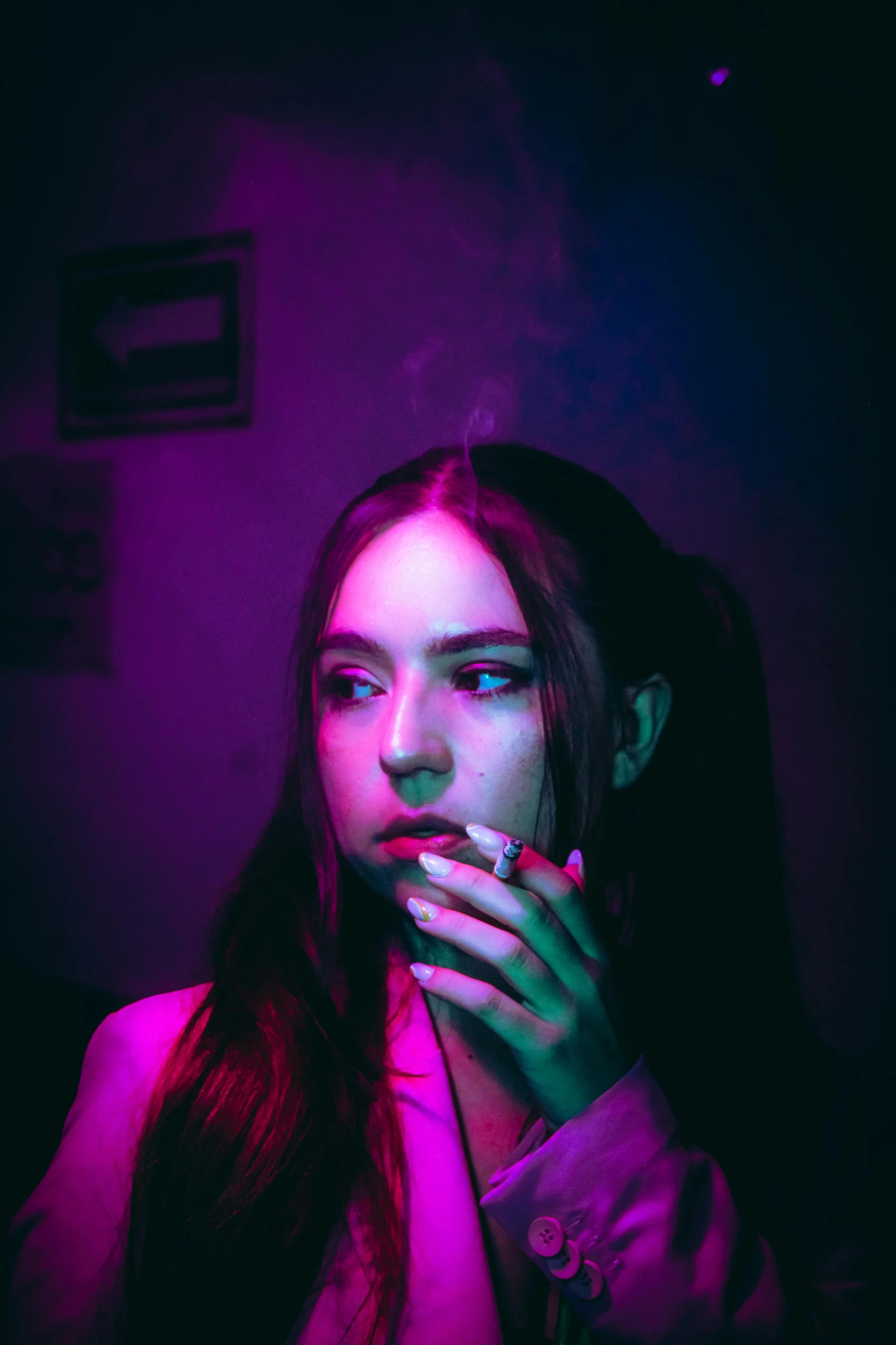 a woman with long hair smoking a cigarette