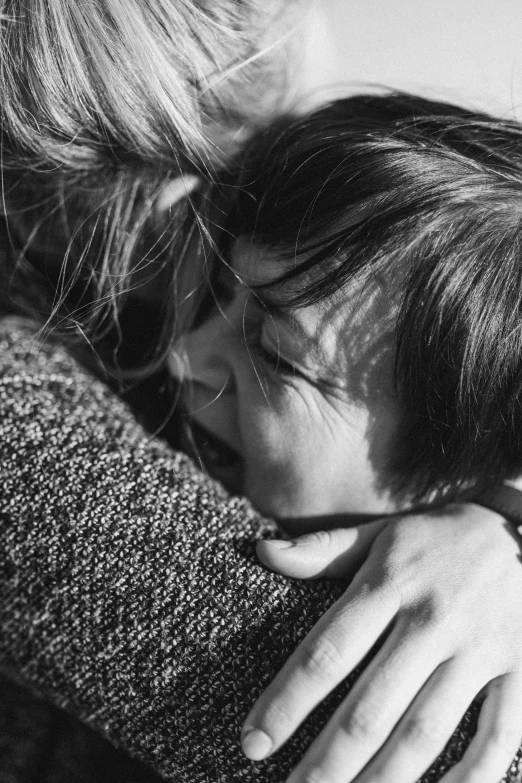 black and white pograph of woman hugging arm on sofa