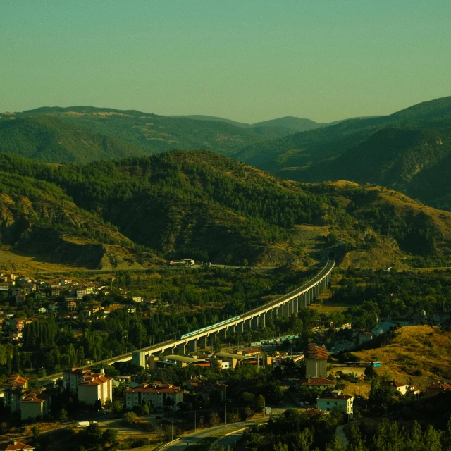 the view of a town, a mountain, and a bridge