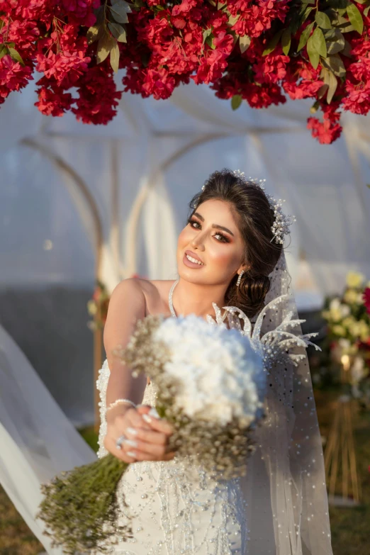 a young woman is wearing a white dress and holding a white bridal