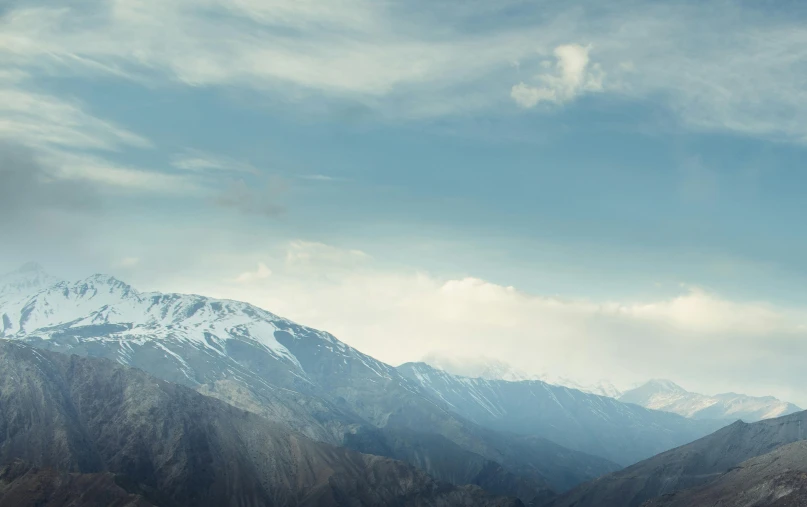 snow capped mountain range in the foreground with a cloudless sky