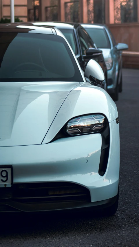 white porsche 9111 on the street next to other cars