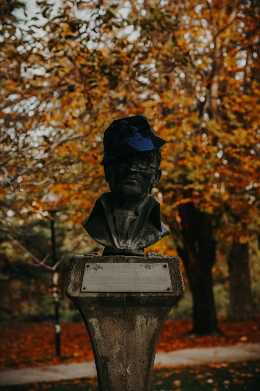 an antique bust in the middle of a park