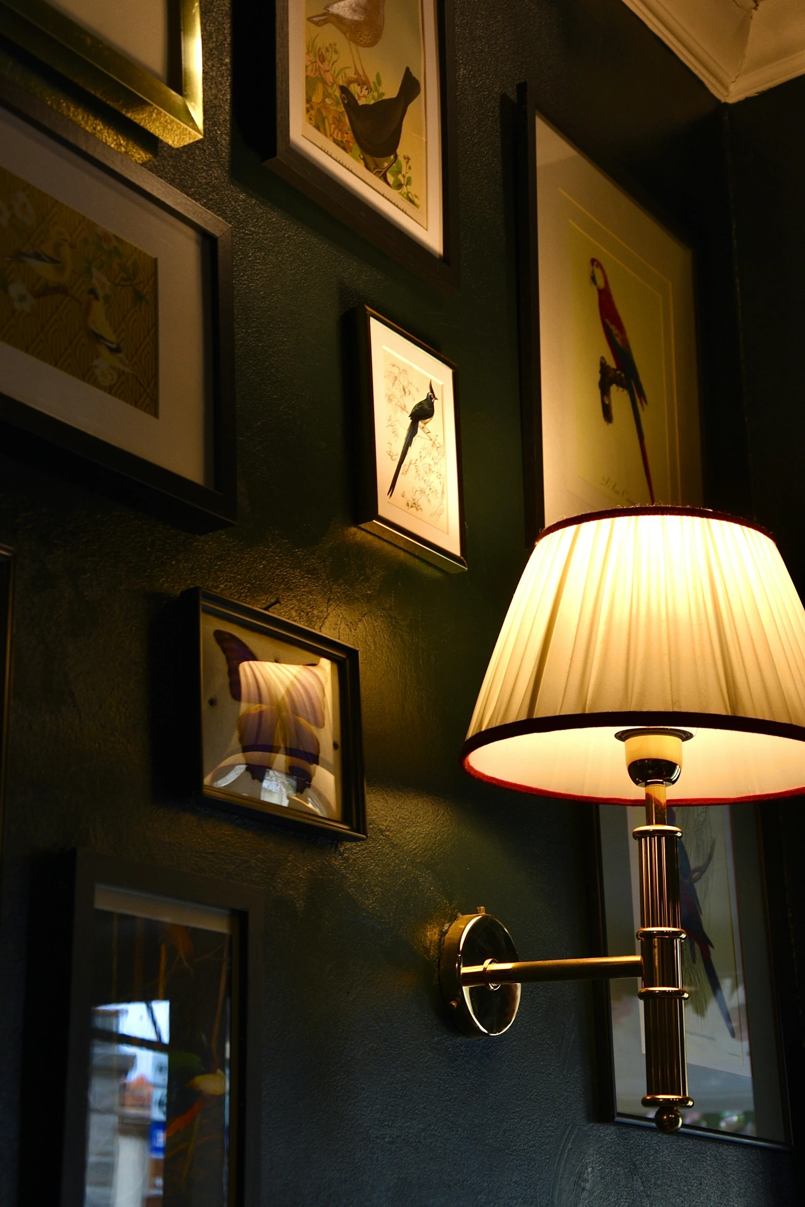 a lamp sitting next to a wall with pictures on it