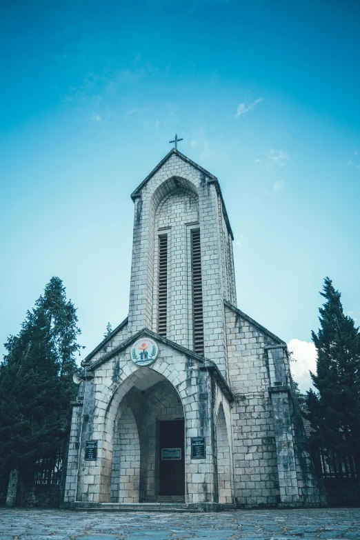 an old church with a steeple surrounded by trees